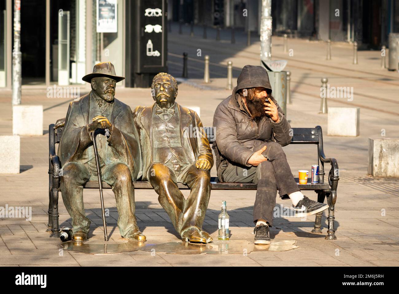 Un uomo che beve e fuma al famoso monumento dei poeti di Piazza Slaveykov nel centro di Sofia, Bulgaria Foto Stock