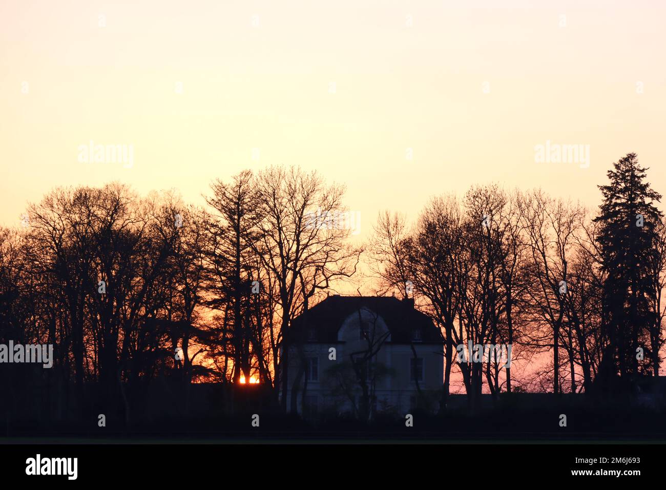 Immagine di copertina tramonto dietro villa solitaria Foto Stock