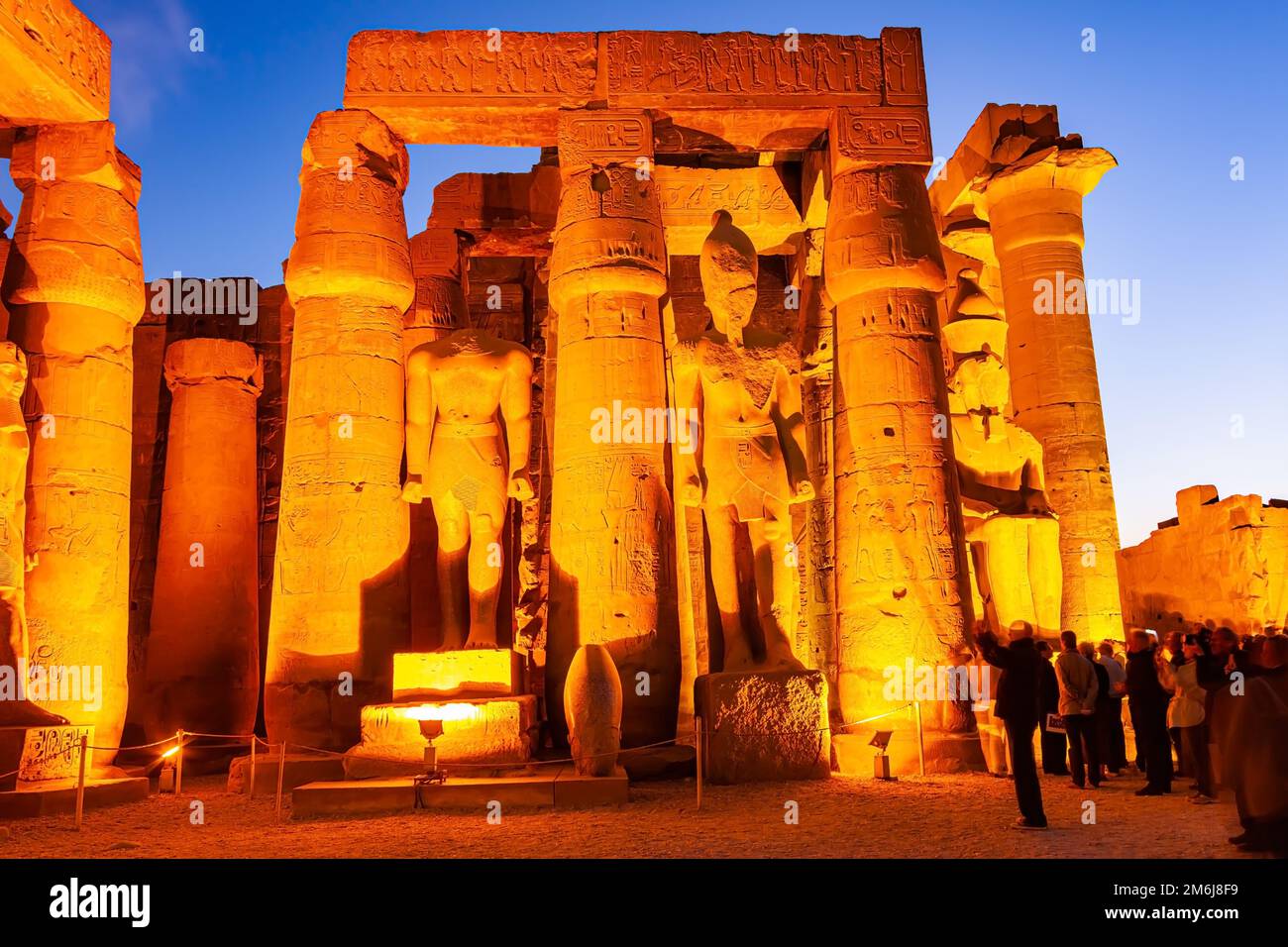 Visitatori sconosciuti visitano le statue del grande faraone nel Tempio di Luxor. Foto Stock
