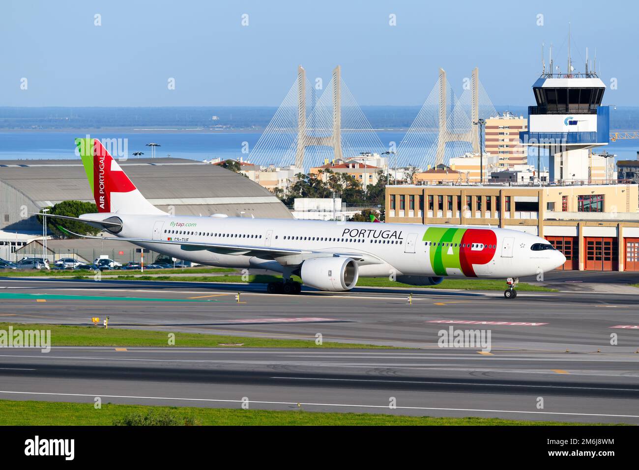 TAP Air Portugal Airbus A330 neo aereo all'aeroporto di Lisbona con ponte Vasco da Gama e torre ATC dietro. Aeromobile A330neo di TAP Portogallo. Foto Stock