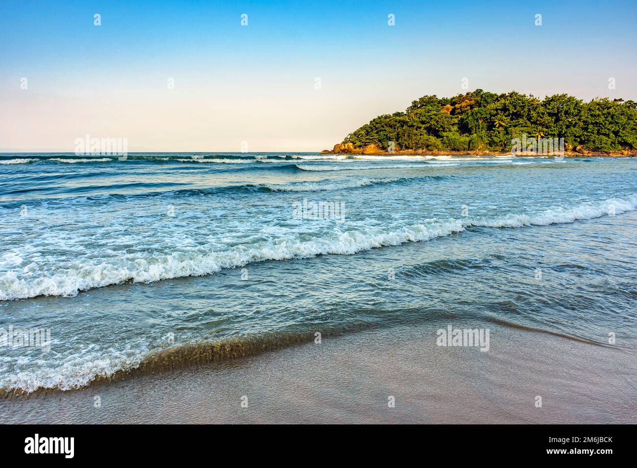 Spiaggia bianca situata nella città di Bertioga e circondata dalla foresta pluviale Foto Stock
