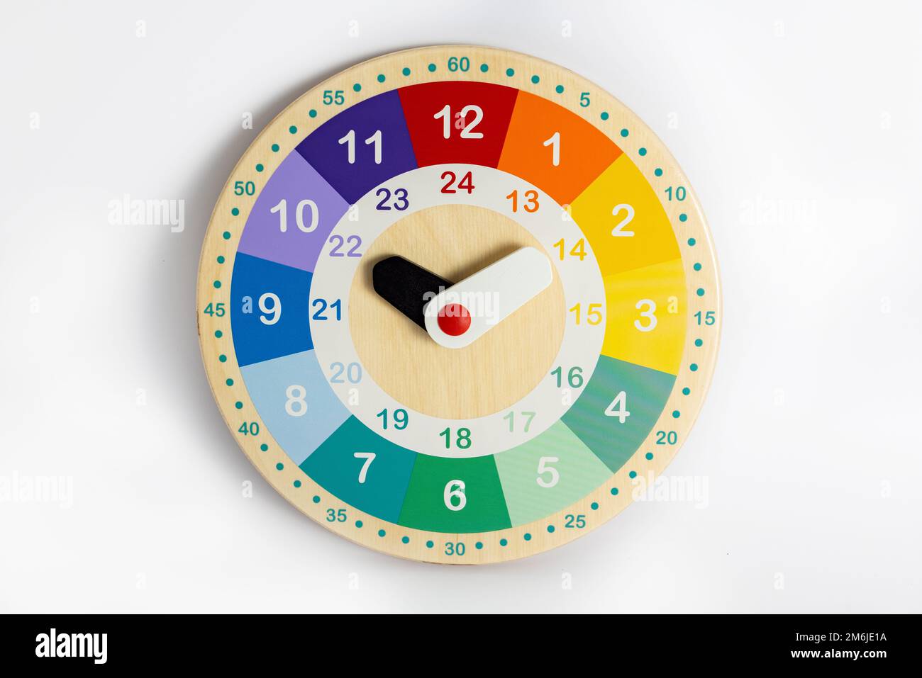 Colorato orologio in legno giocattolo isolato su sfondo bianco. Studio del tempo da parte del bambino. Foto Stock