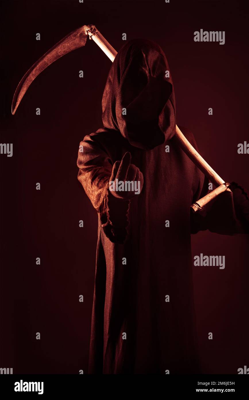 Morte tenendo una vecchia falce affilata sulle spalle della morte che si chiama con il dito Foto Stock