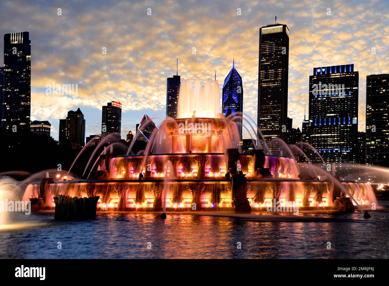 La fontana di Buckingham è scattata per catturare il bellissimo tramonto e le luci colorate cambiano illuminando lo skyline di Chicago sullo sfondo. Foto Stock