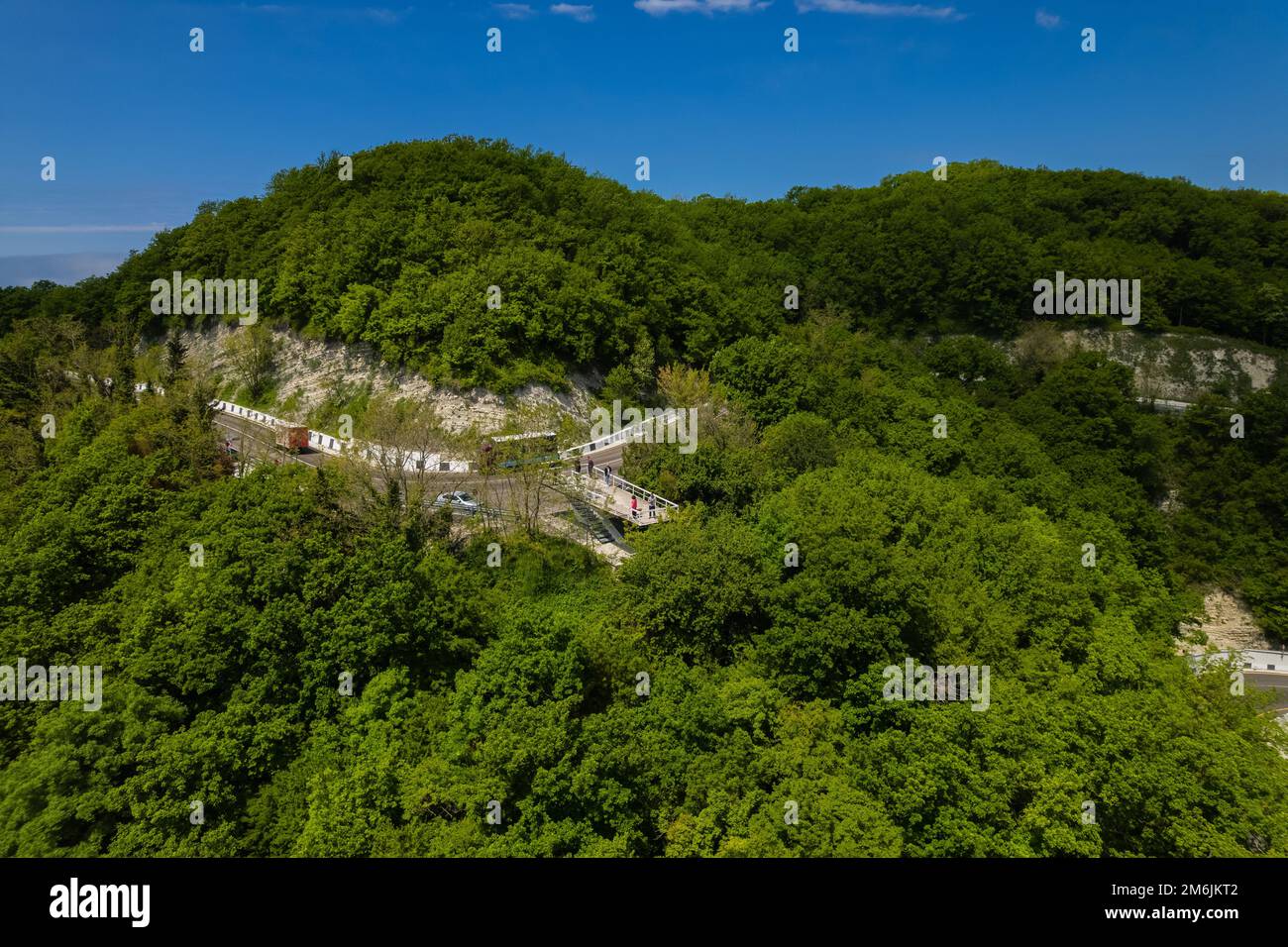 Vista aerea della strada tortuosa dal passo di montagna alto. Ottima gita su strada attraverso i fitti boschi. Vista panoramica degli uccelli. Foto Stock