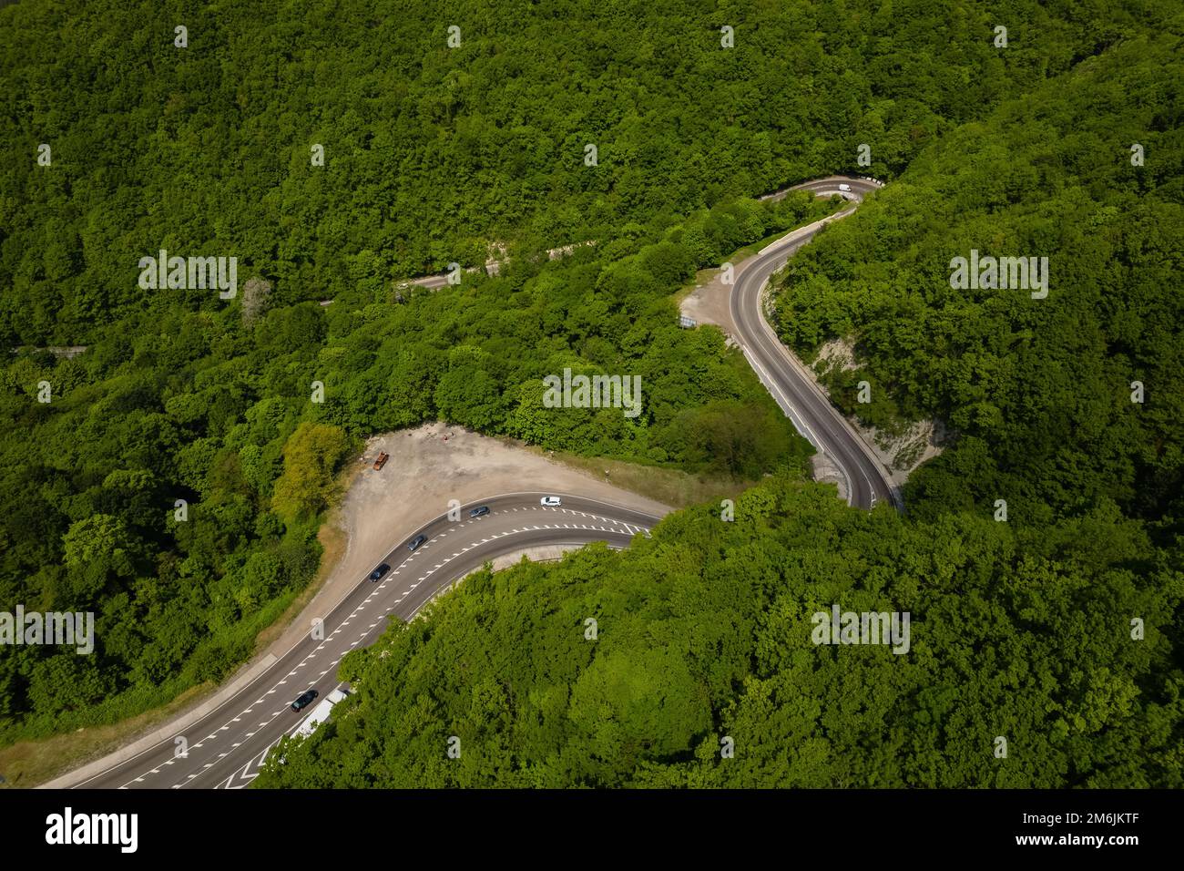 Vista aerea della strada tortuosa dal passo di montagna alto. Ottima gita su strada attraverso i fitti boschi. Vista panoramica degli uccelli. Foto Stock