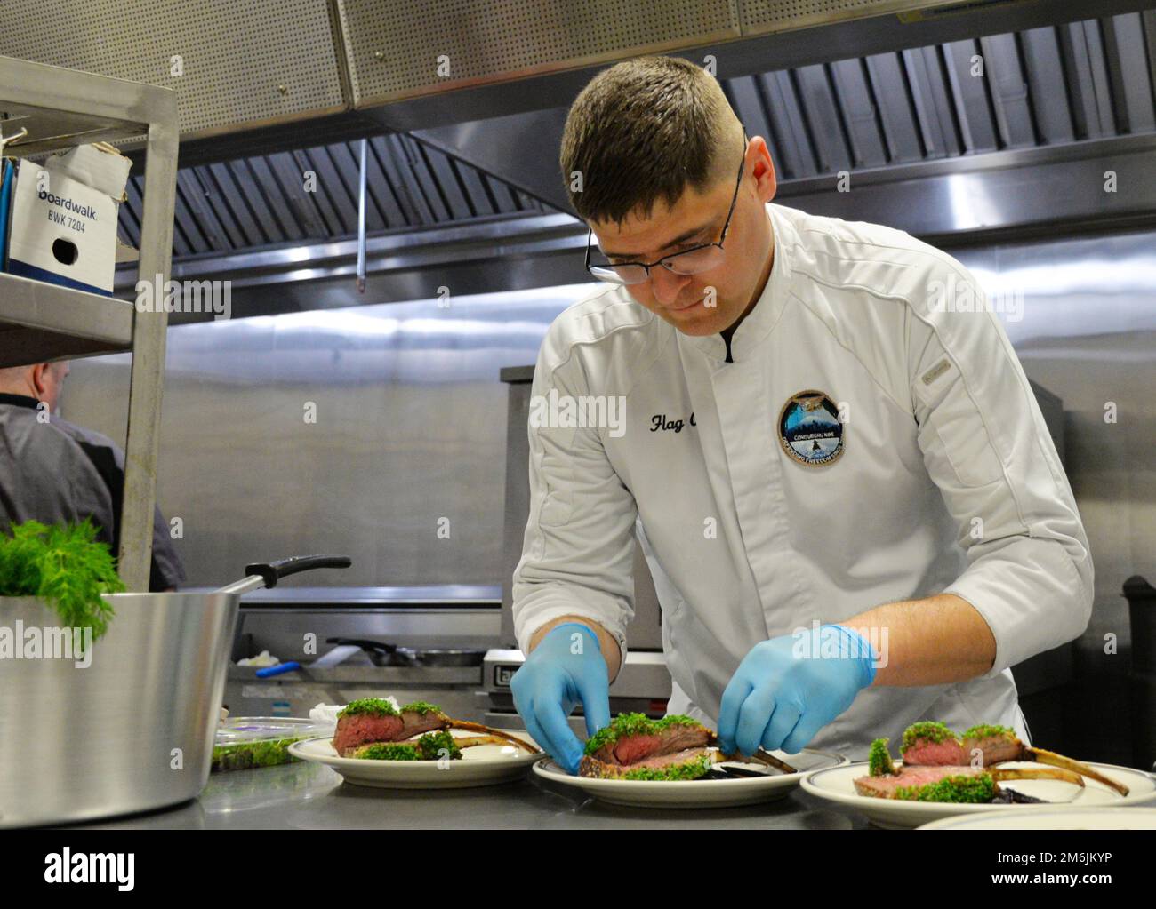 SILVERDALE, Wash--Uno studente prepara un piatto durante il NAVSUP FLC Puget Sound Navy Food Management Team Wardroom Seminar Aprile 27. Il seminario fornisce agli Specialisti della Marina le informazioni e le abilità necessarie per operare in una wardroom sia a terra che a galla. Durante il seminario gli studenti preparano e servono un pasto formale che si aspettano di servire a visitatori illustri e dignitari stranieri. Foto Stock