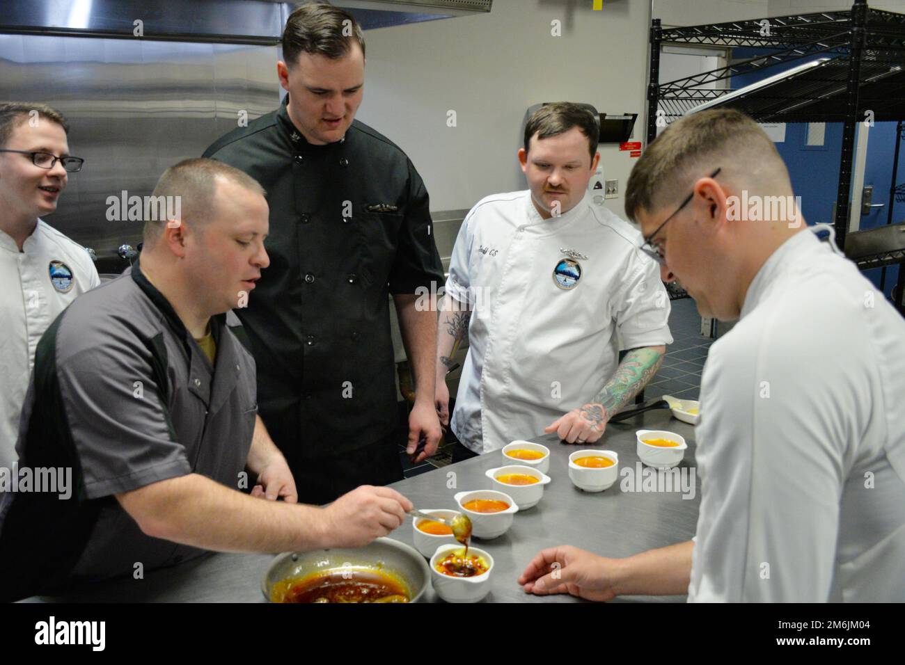 SILVERDALE, Wash--Chief Culinary Specialist Brian McNulty (in basso a sinistra) dimostra di aggiungere il tocco finale a un dessert durante il NAVSUP FLC Puget Sound Food Management Team Wardroom Seminar del 27 aprile. Il seminario fornisce agli Specialisti della Marina le informazioni e le abilità necessarie per operare in una wardroom sia a terra che a galla. Durante il seminario gli studenti preparano e servono un pasto formale che si aspettano di servire a visitatori illustri e dignitari stranieri. Foto Stock