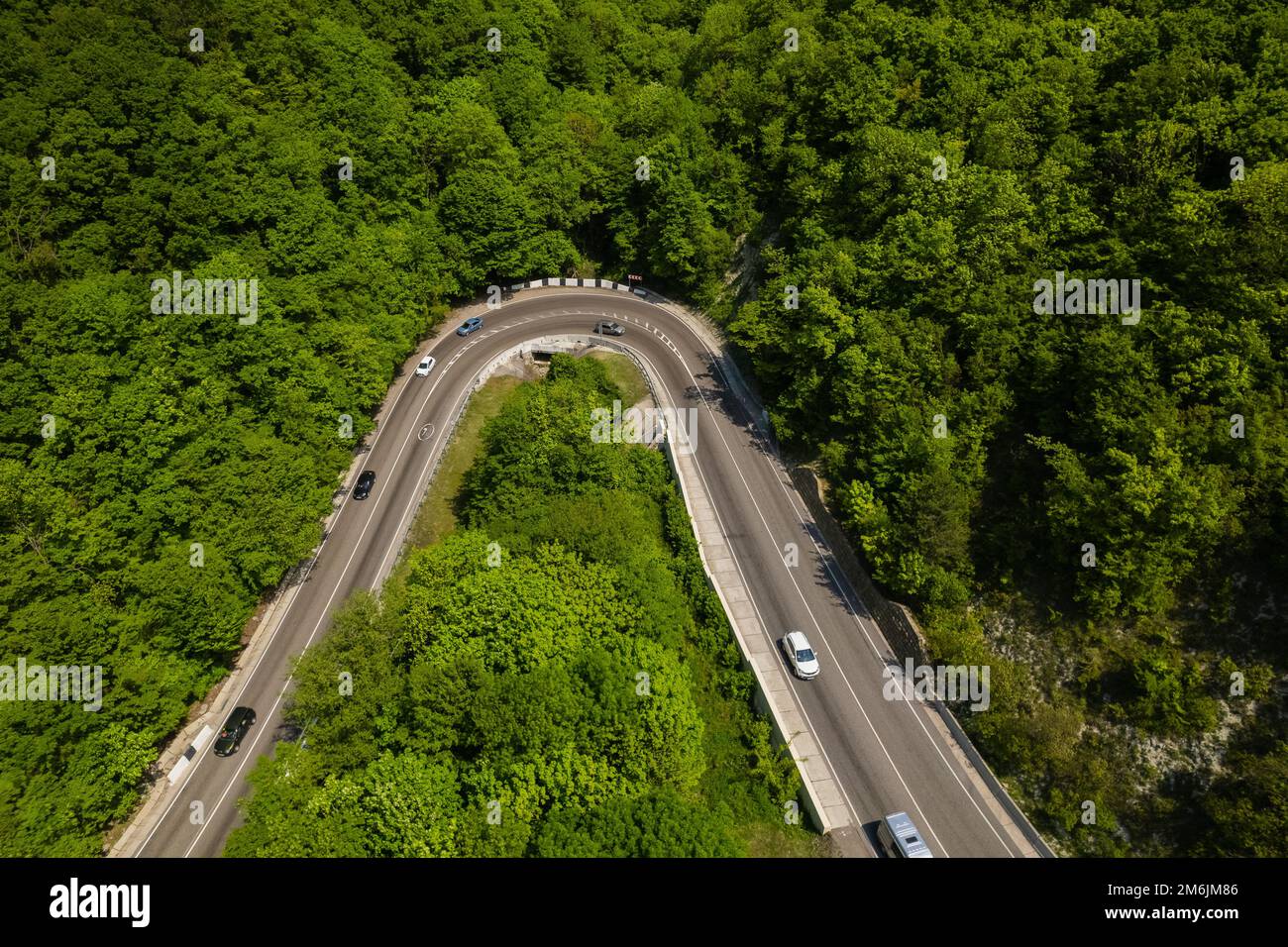 Vista aerea della strada tortuosa dal passo di montagna alto. Ottima gita su strada attraverso i fitti boschi. Vista panoramica degli uccelli. Foto Stock