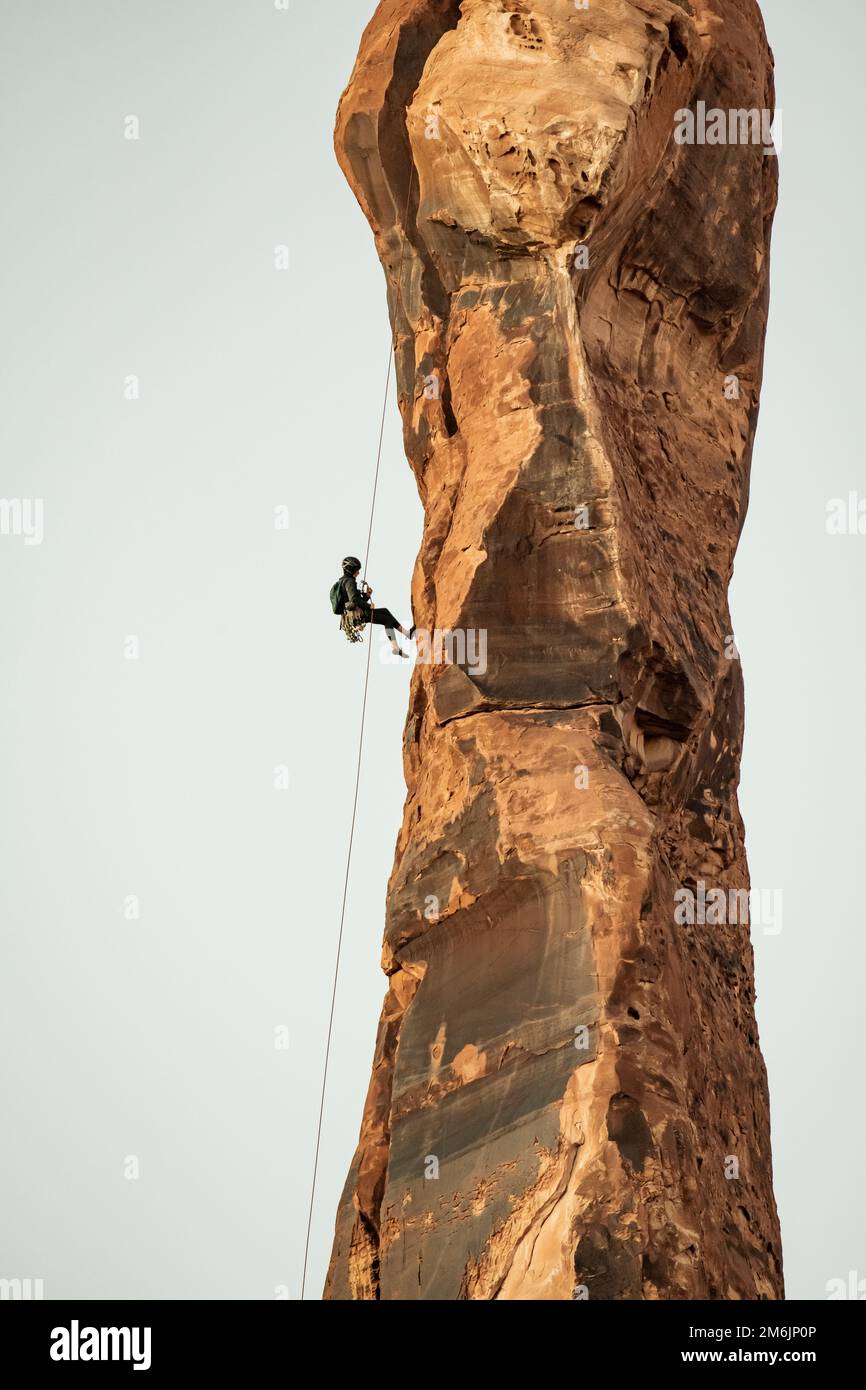 Vista dal basso angolo della donna che si rapina dalla torre rocciosa del Bride Canyon Foto Stock