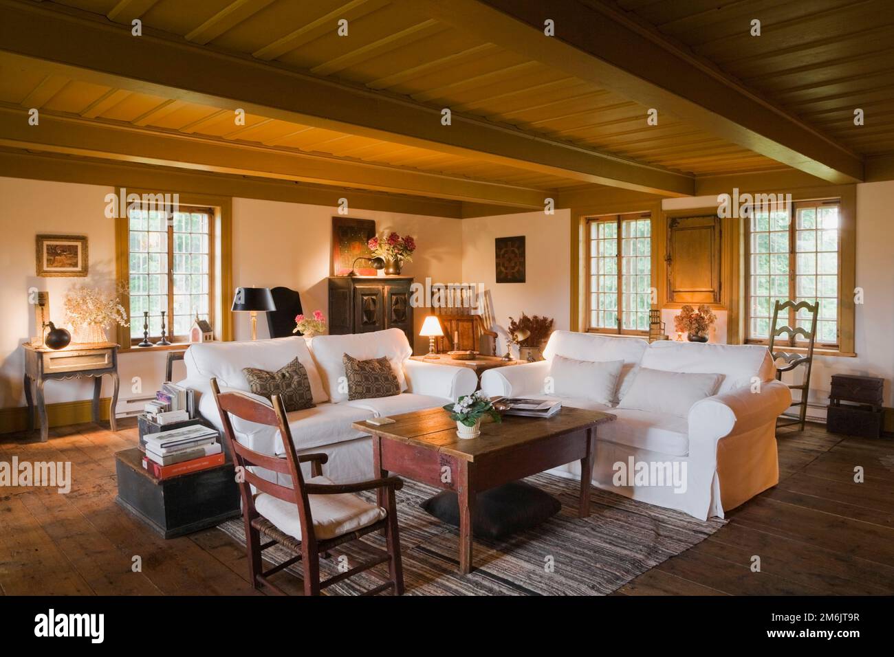 Divani tappezzati in tessuto bianco nel soggiorno all'interno della vecchia casa stile cottage regime francese del 1752. Foto Stock