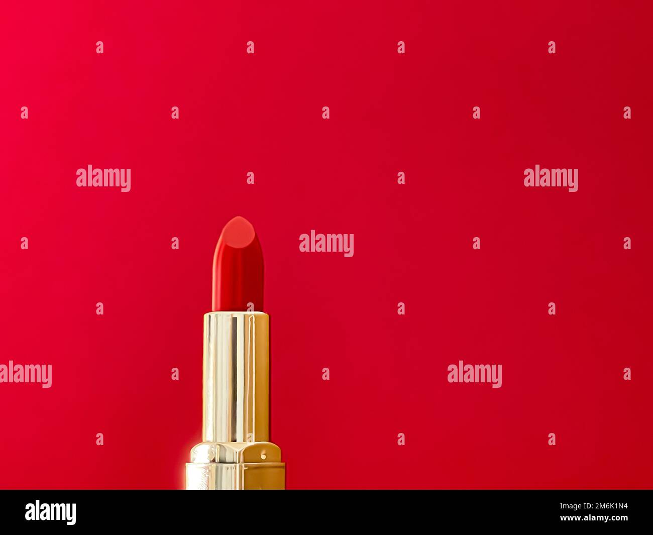 Rossetto rosso in tubo dorato su sfondo colorato, trucco di lusso e cosmetici per il design di prodotti di marca di bellezza Foto Stock