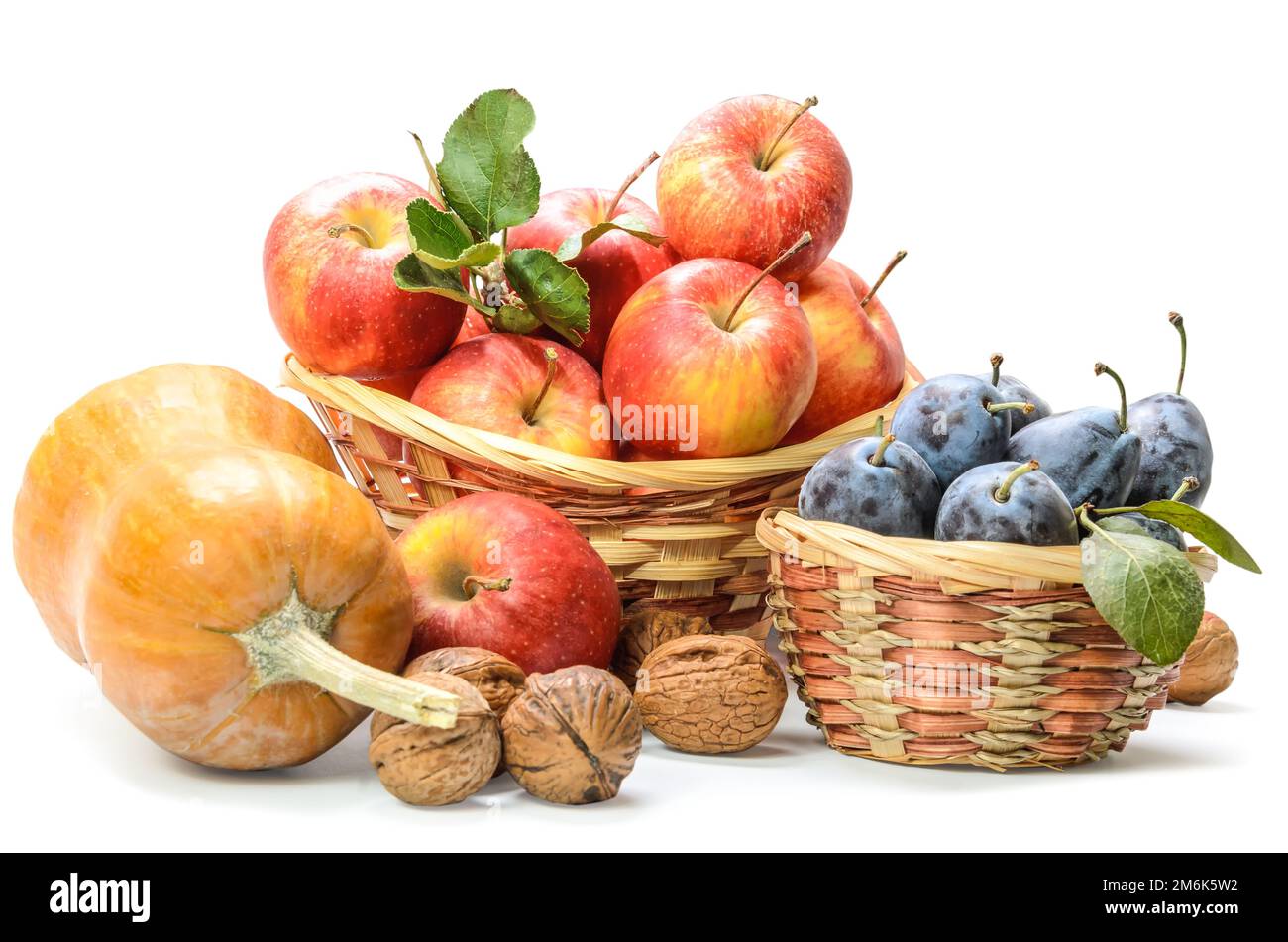 Mele in un cestino e altri frutti su sfondo bianco con ombra morbida Foto Stock