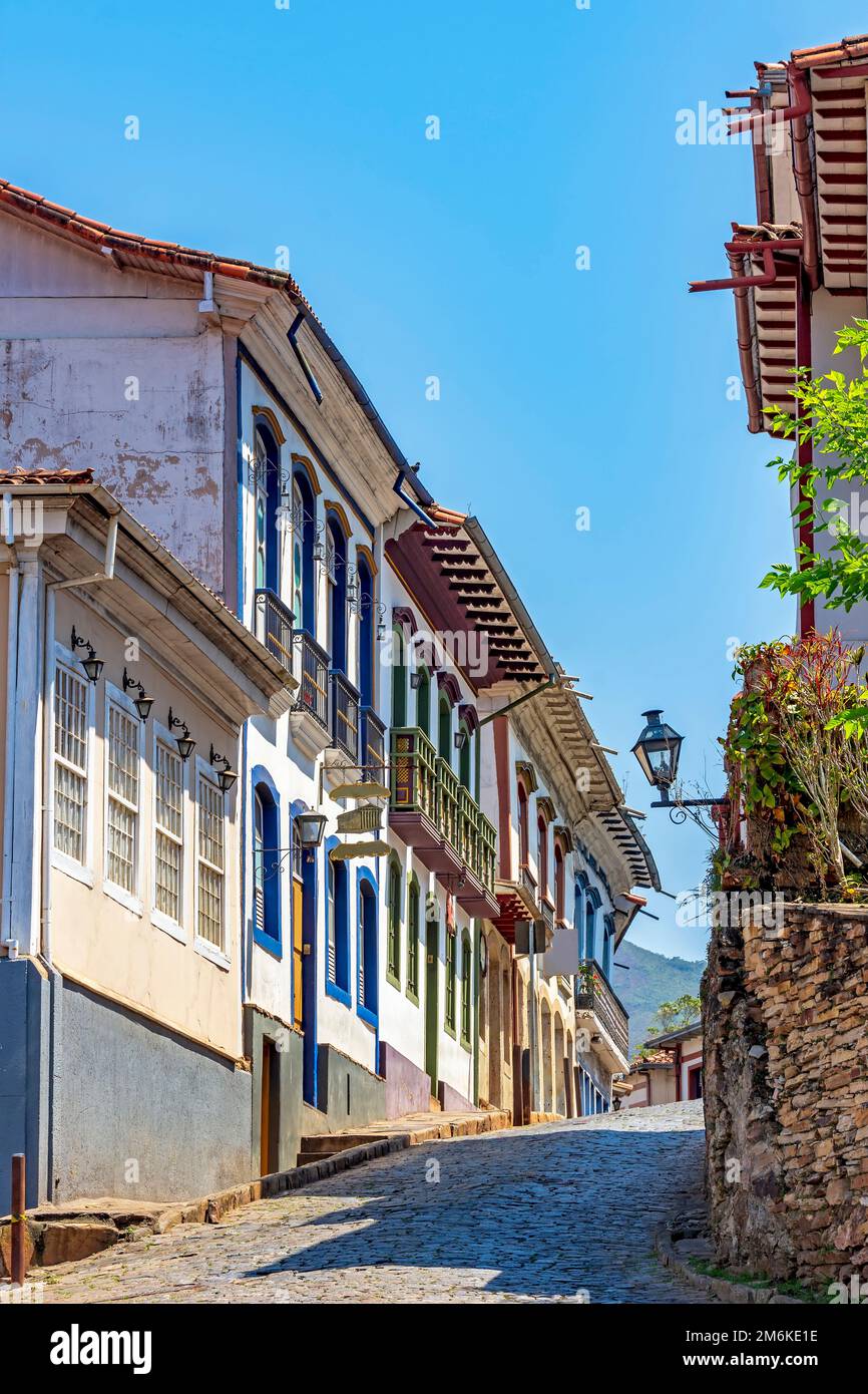 Strada acciottolata con vecchie e colorate case coloniali a Ouro Preto Foto Stock
