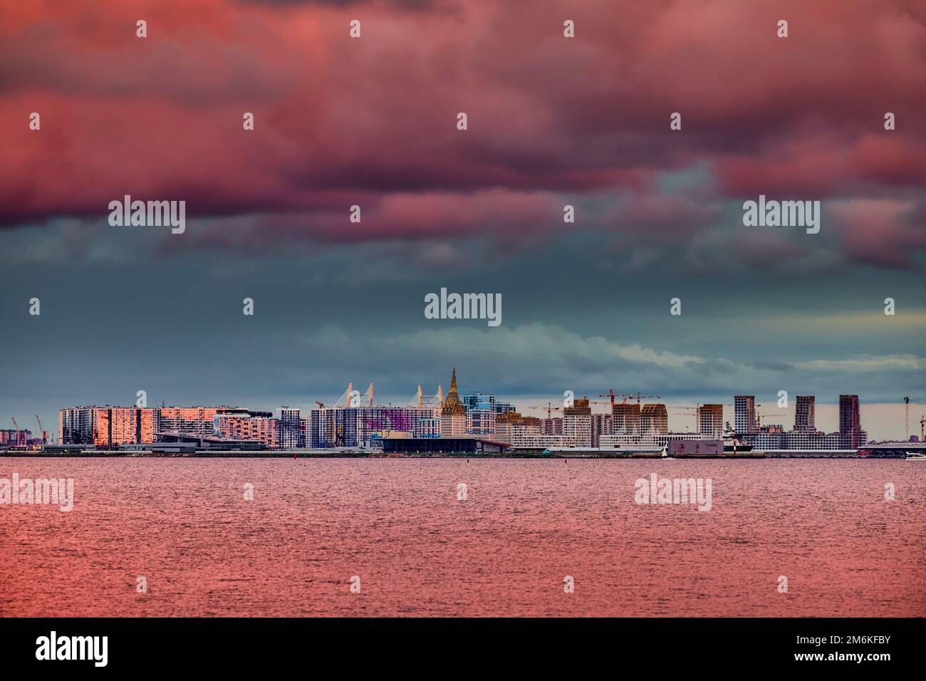 Cielo rosa magico sopra il complesso residenziale in costruzione sul lungofiume del fiume Neva sull'isola di Vasilievsky in sole Foto Stock Cielo rosa magico sopra il complesso residenziale in costruzione sul lungofiume del fiume Neva sull'isola di Vasilievsky in sole Foto Stock