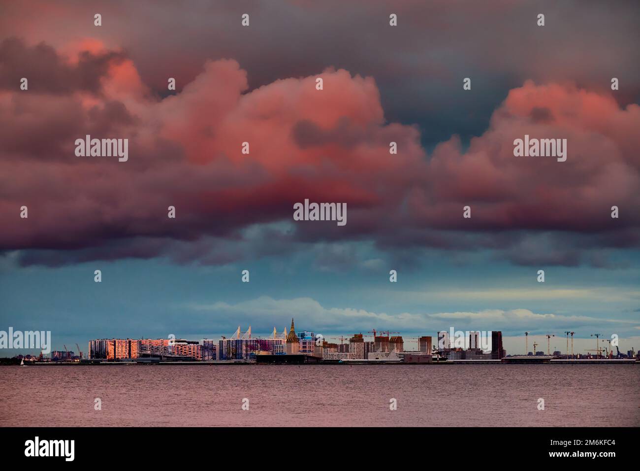 Cielo rosa magico sopra il complesso residenziale in costruzione sul lungofiume del fiume Neva sull'isola di Vasilievsky in sole Foto Stock