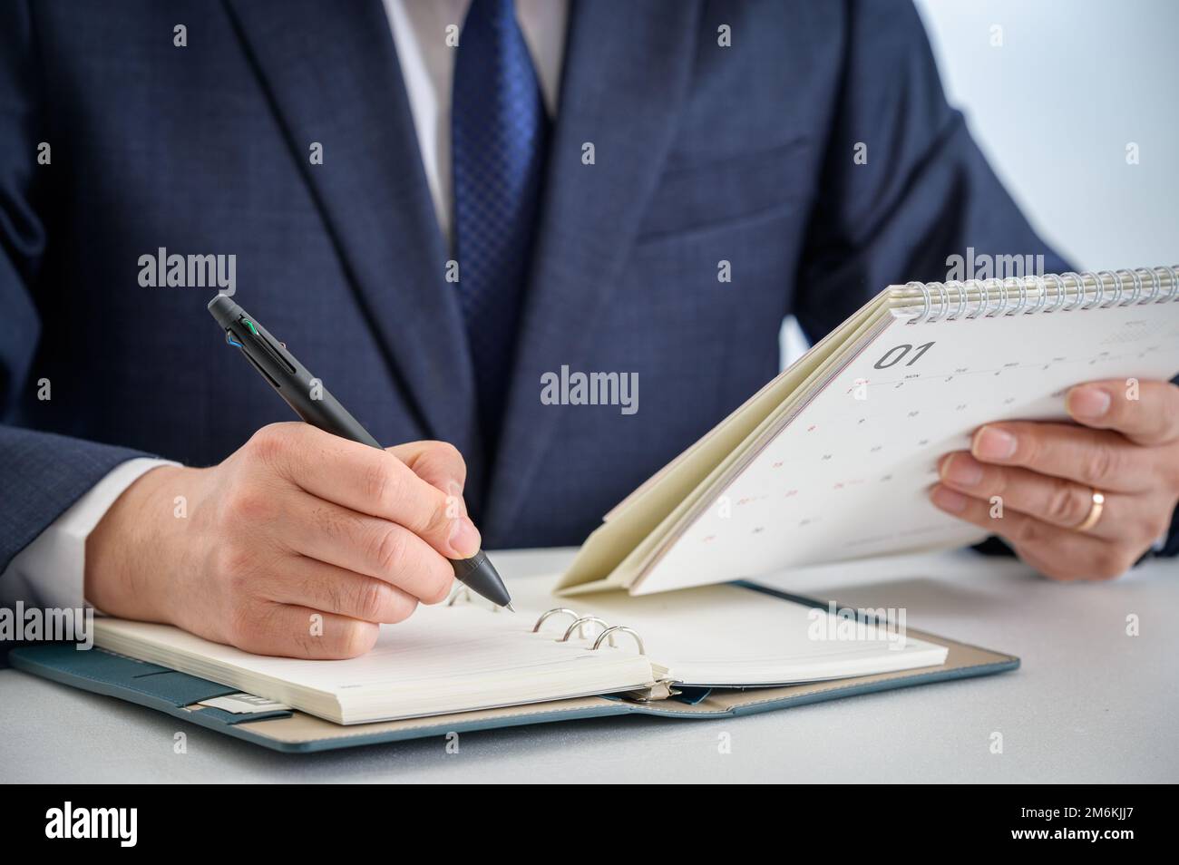 Mani di un uomo d'affari che scrive un programma o che registra le idee in un diario Foto Stock