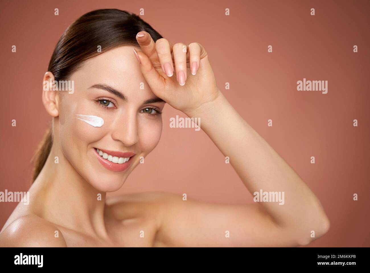 Donna sorridente con crema all'umidità Foto Stock