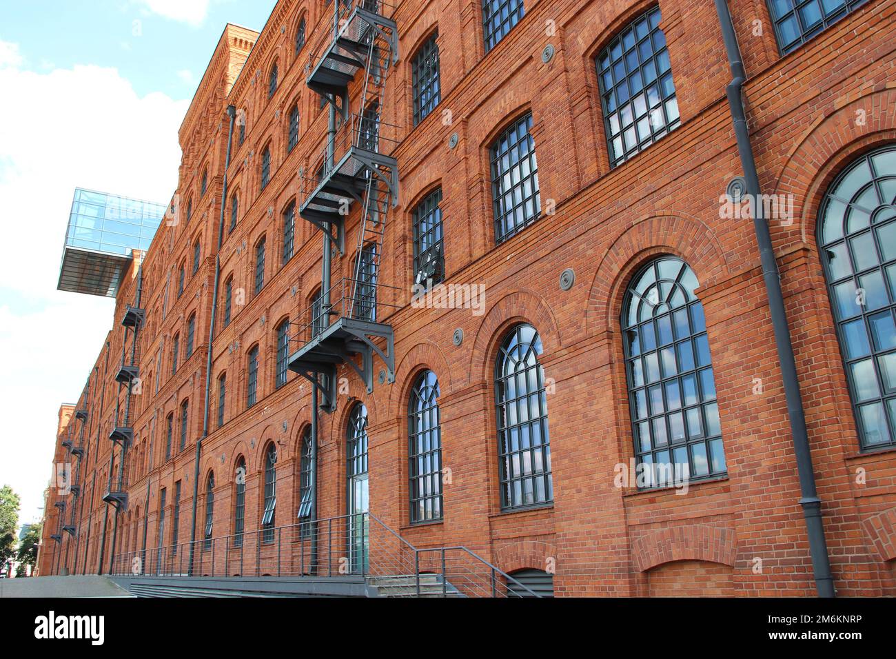 Facciata di un vecchio edificio in mattoni. Vecchio edificio di fabbrica con finestre nella città polacca di Lodz Foto Stock