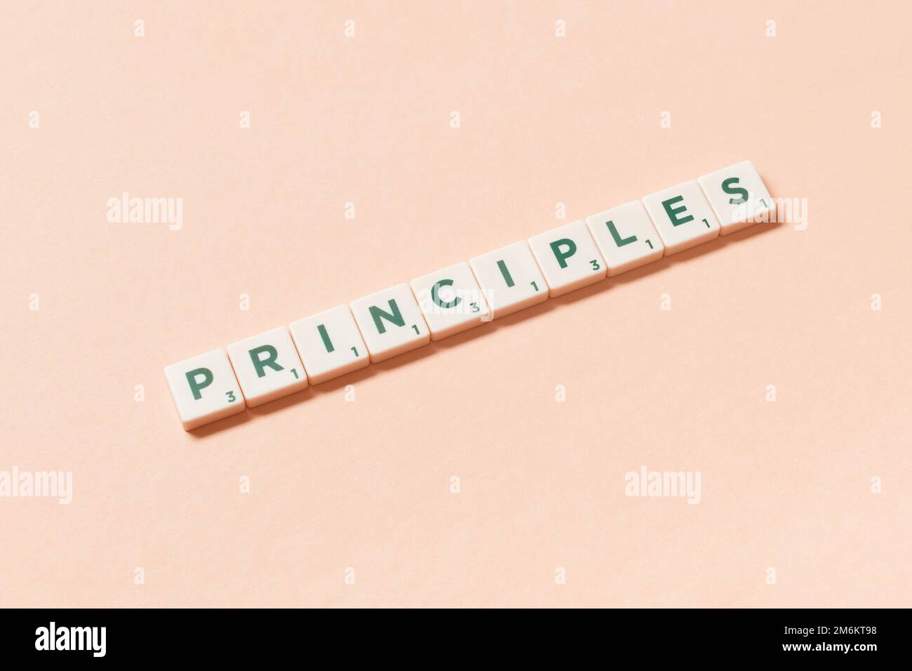 Principi formati di scrabble piastrelle su sfondo beige. Foto Stock