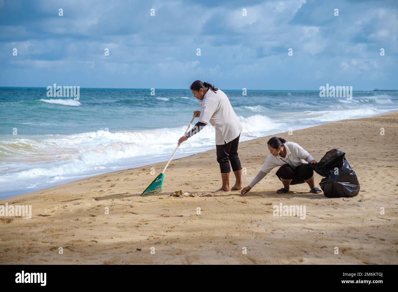 Persone pulizia rifiuti di plastica sulla spiaggia di Phuket Thailandia Foto Stock