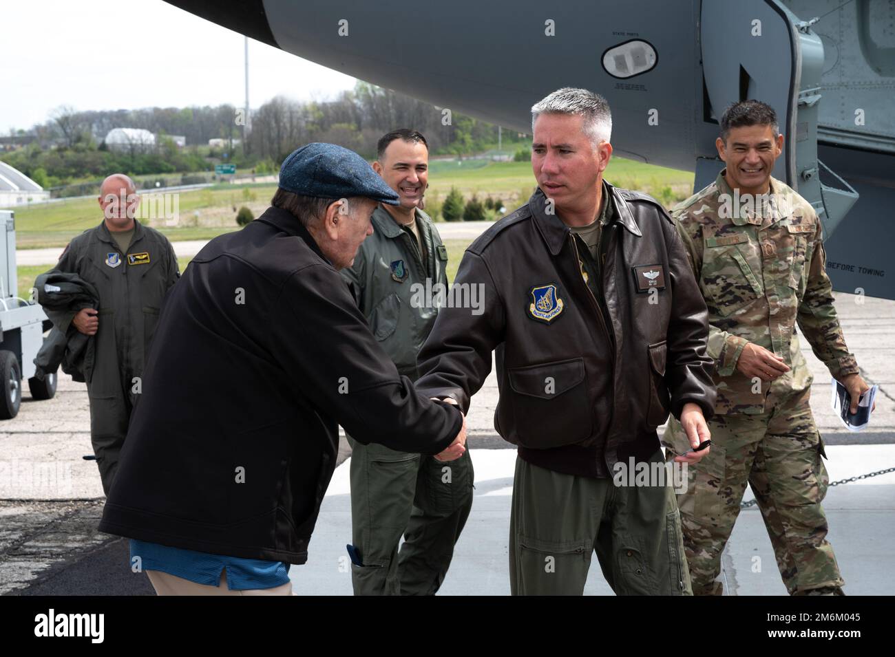 Koi Lau, pilota di 203rd Air Refueling Squadron, scrolla le mani con un veterano della guerra del Vietnam 30 aprile 2022, base dell'aeronautica militare Wright-Patterson, Ohio. L'equipaggio di Lau è volato dalle Hawaii per trasferire una storica nave da trasporto KC-135R Statotanker al Museo Nazionale degli Stati Uniti Forza aerea. Foto Stock