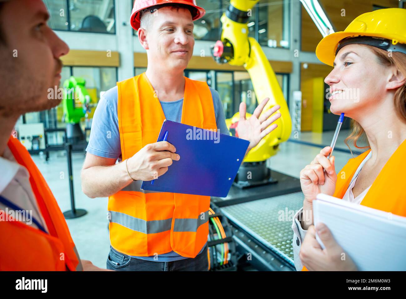 Ingegneri che consultano robot industriali Foto Stock
