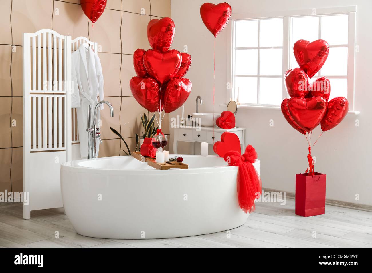 Interno del bagno decorato per San Valentino con palloncini a forma di  cuore e regali Foto stock - Alamy