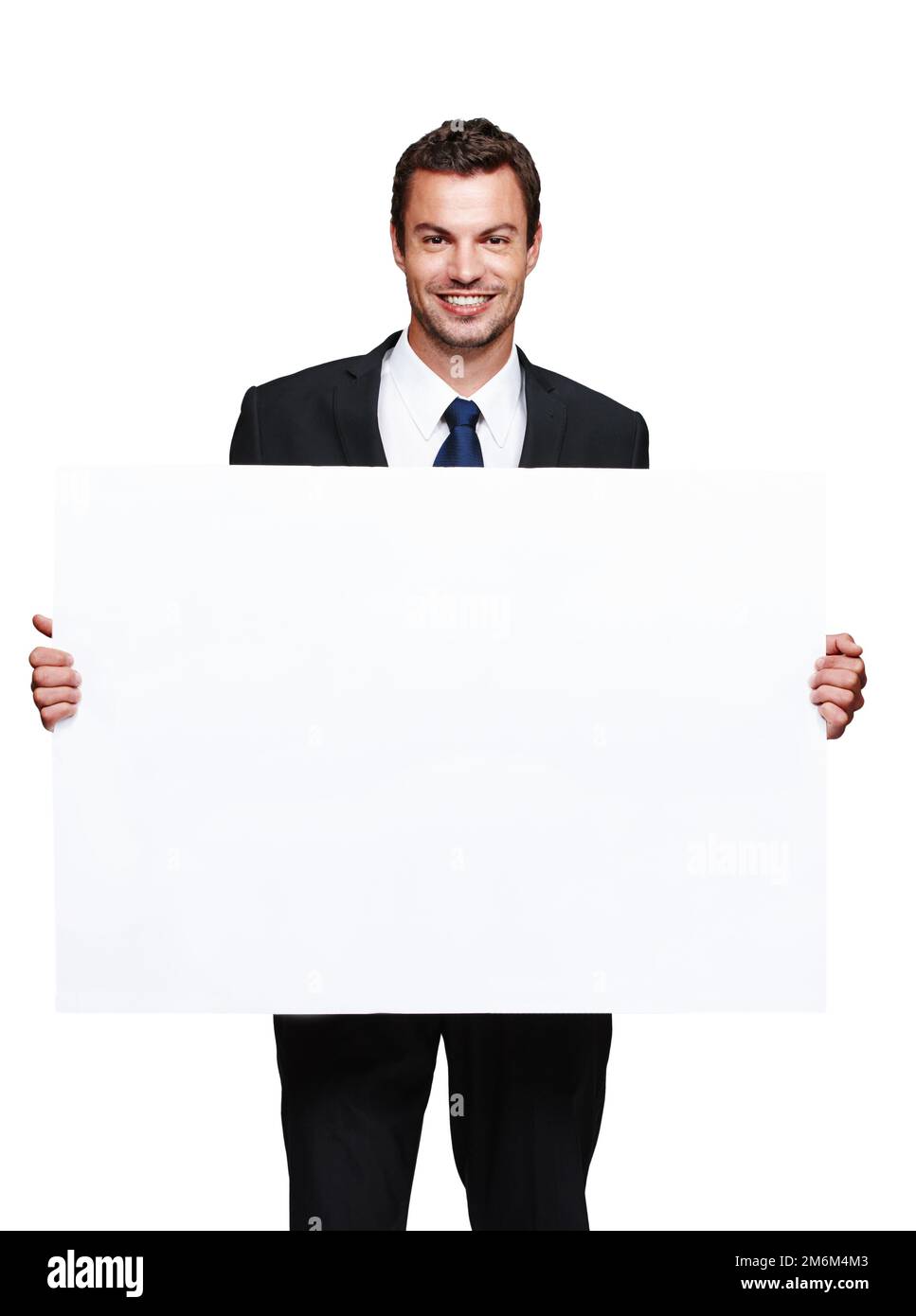 Ho risparmiato questo spazio per te. Un bel giovane uomo d'affari che tiene una lavagna vuota mentre isolato su bianco. Foto Stock