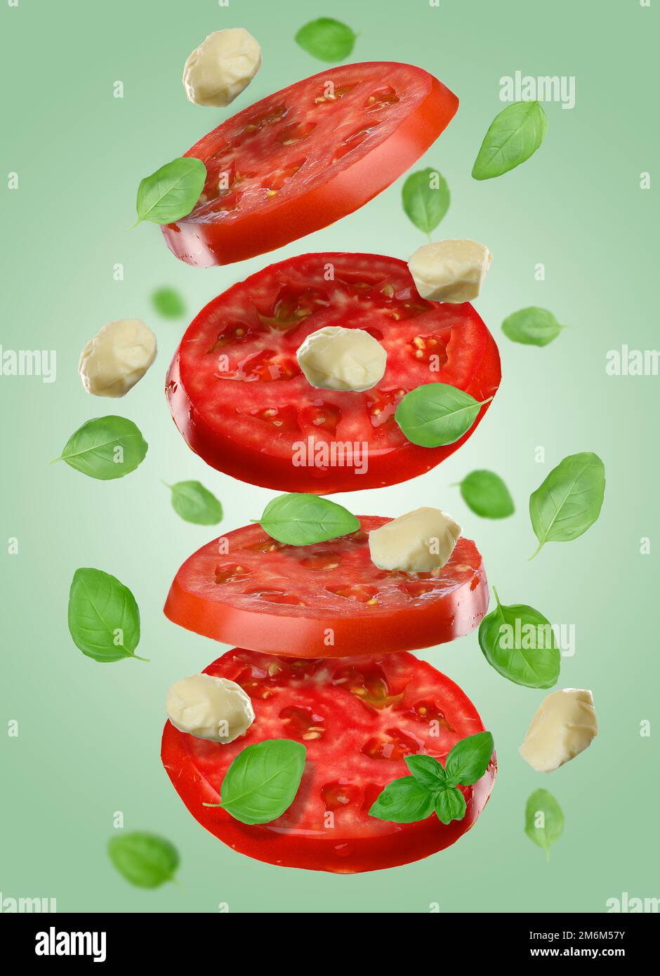 Pezzo rotondo di pomodoro rosso maturo isolato su fondo verde Foto Stock