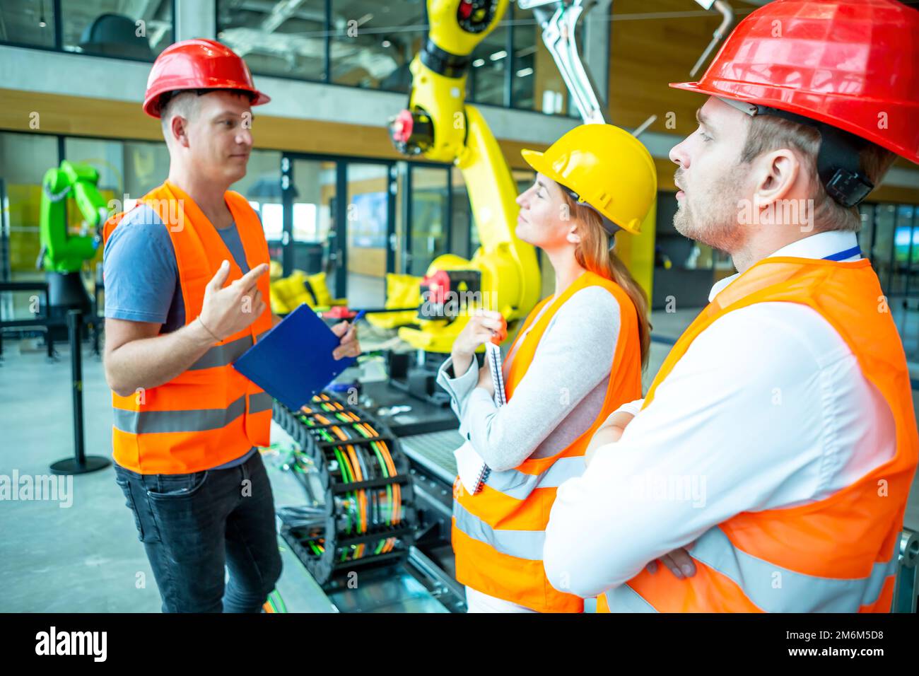 Ingegneri che consultano robot industriali Foto Stock