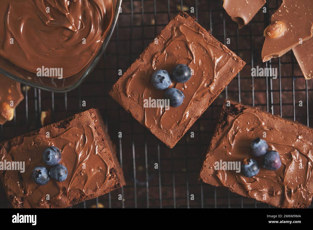 Composizione di quadrati di brownie al cioccolato fatti in casa freschi che fondono cioccolato e mirtilli freschi Foto Stock