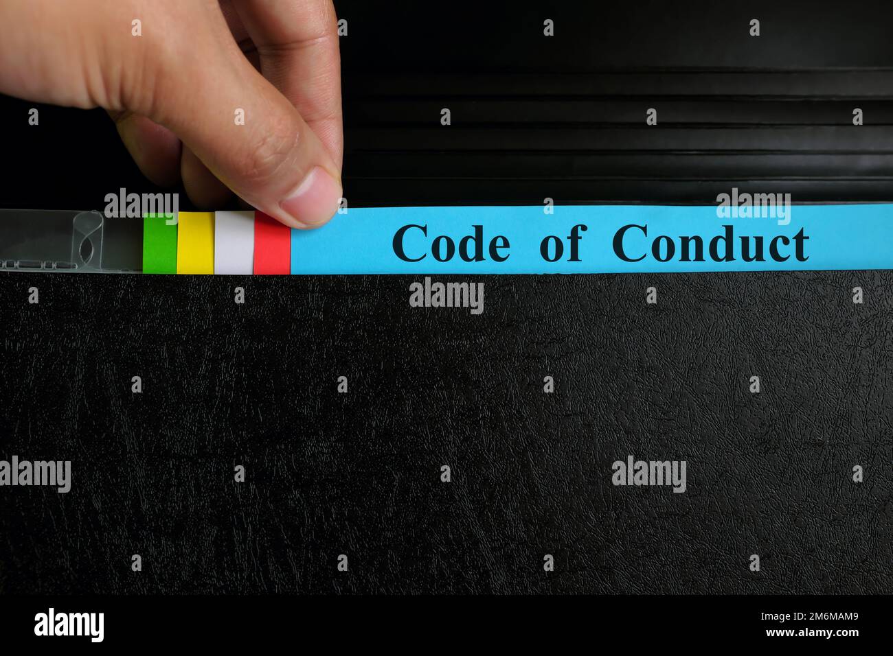 Record del file del codice di condotta di prelievo a mano nella cartella del raccoglitore nero. Codice di condotta aziendale concetto di standard etico. Foto Stock