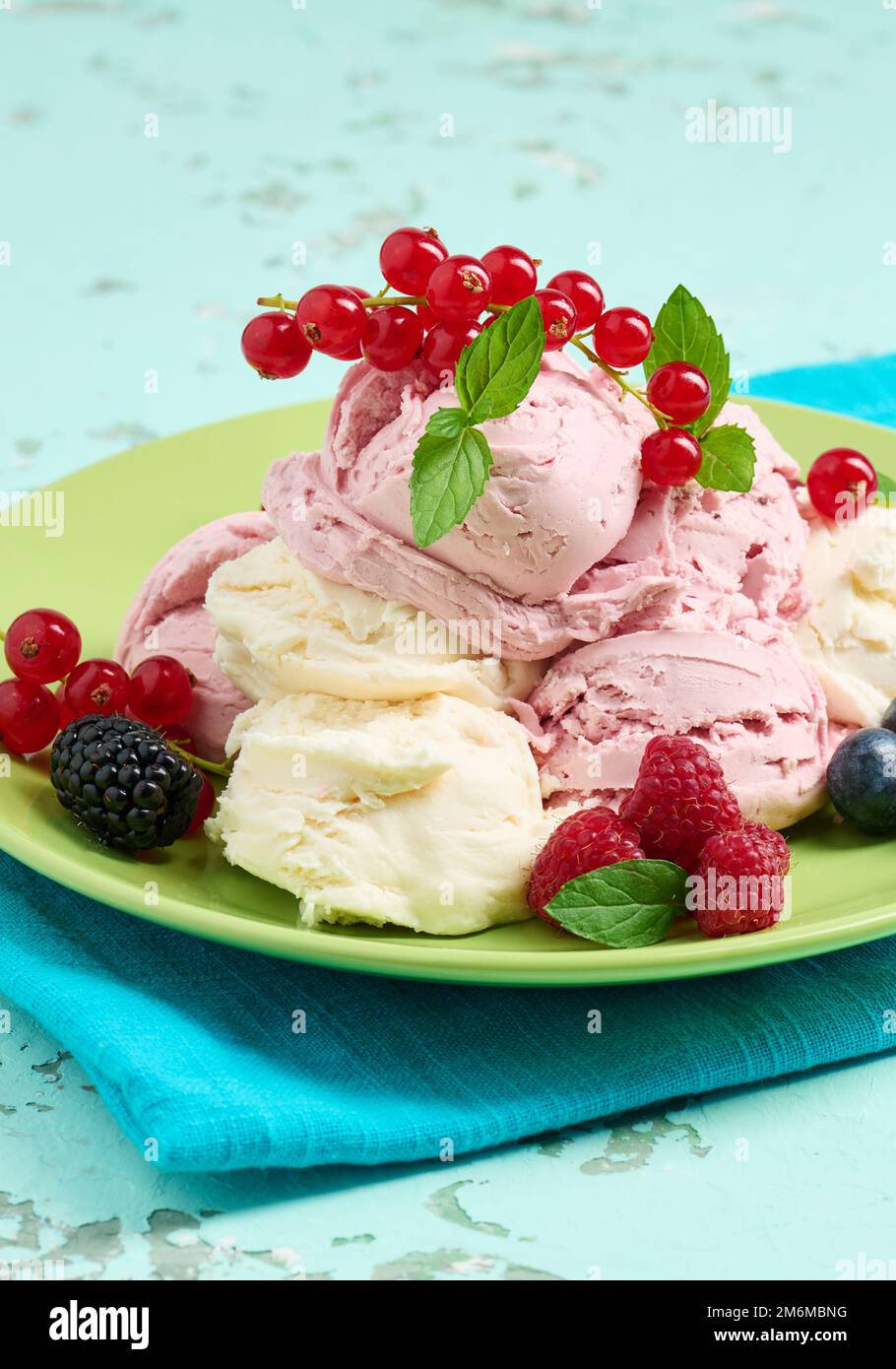 Misurini per gelato alla vaniglia e al lampone su un piatto rotondo verde Foto Stock
