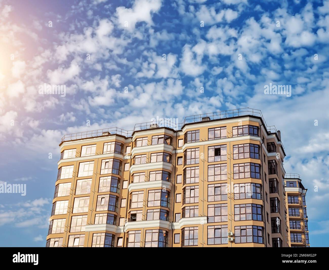 Il nuovo edificio è pronto per la messa in servizio. Un nuovo edificio residenziale multi-appartamenti con finestre panoramiche contro un'sk blu Foto Stock