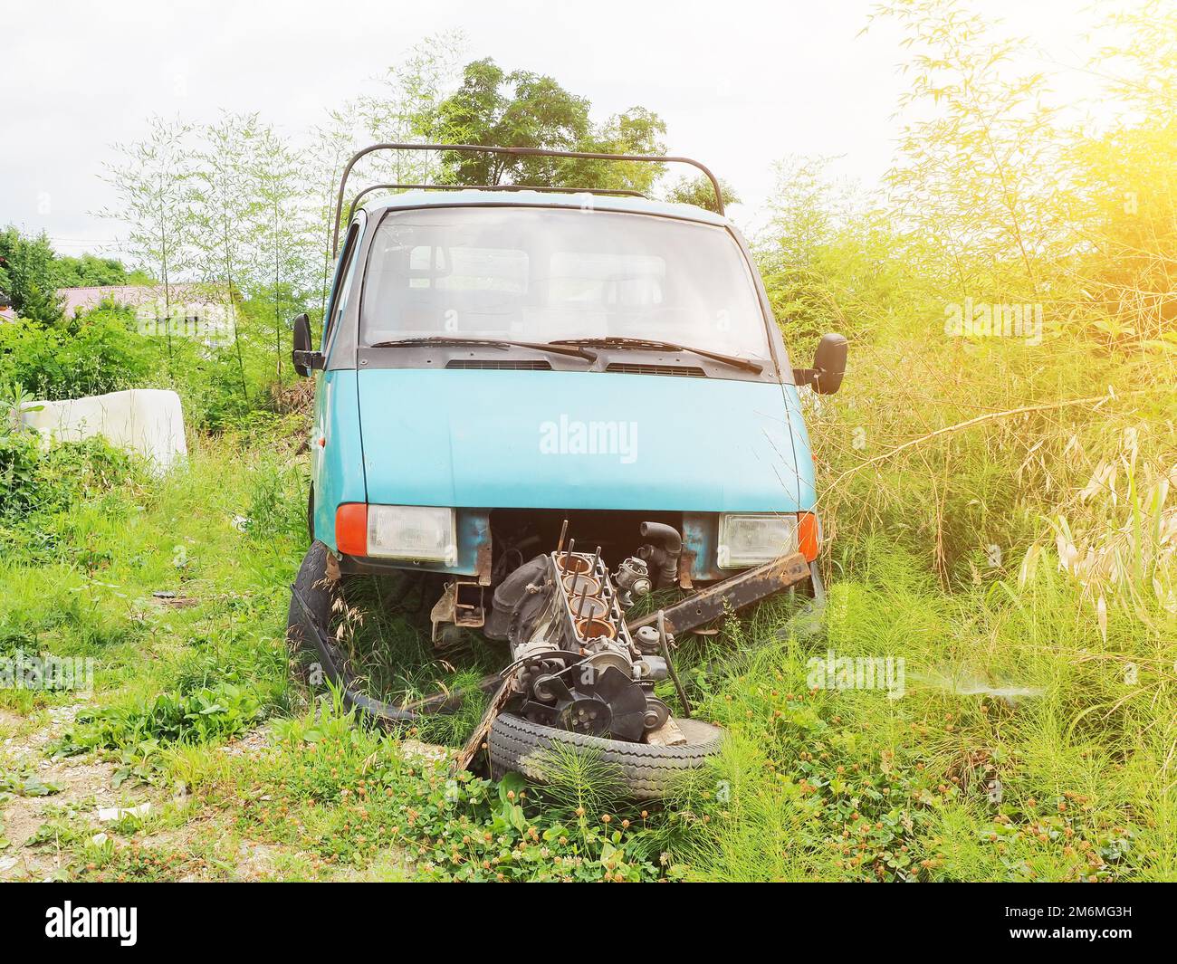 Motore del carrello rotto. Auto obsoleta abbandonata in campagna. Vettura smontata per parti. Sostituzione del motore. Foto Stock