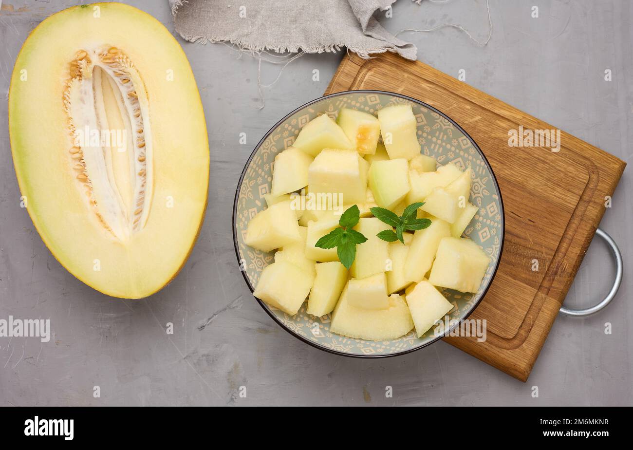 Pezzi di melone a fette in un piatto rotondo grigio sul tavolo Foto Stock