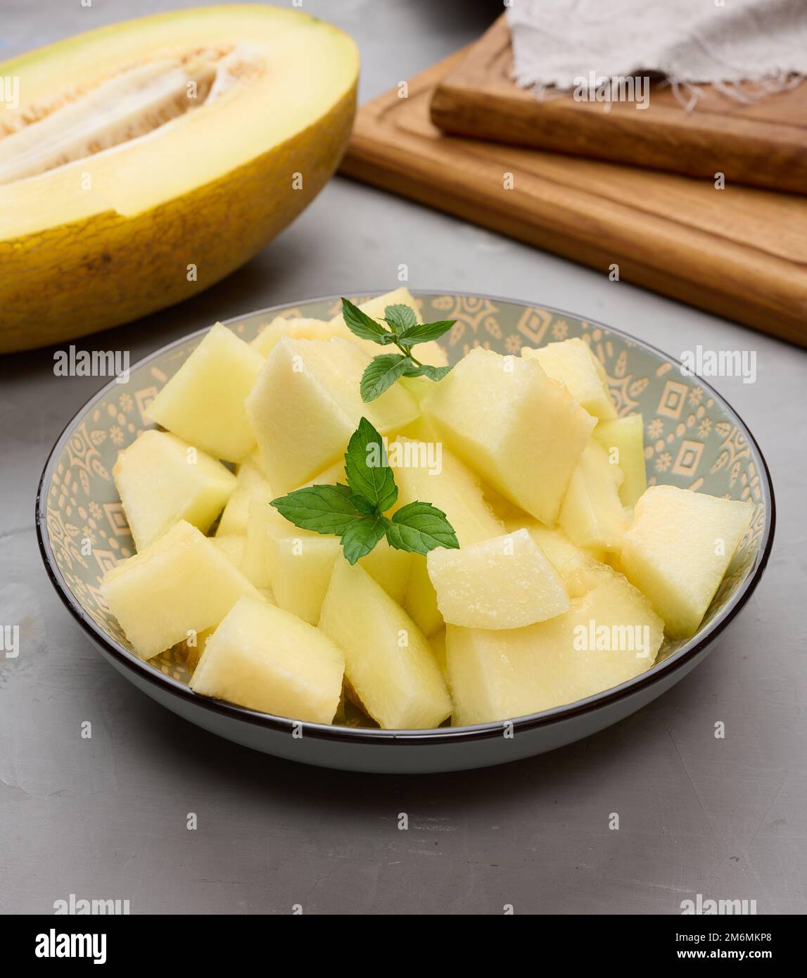 Pezzi di melone a fette in un piatto rotondo grigio sul tavolo Foto Stock