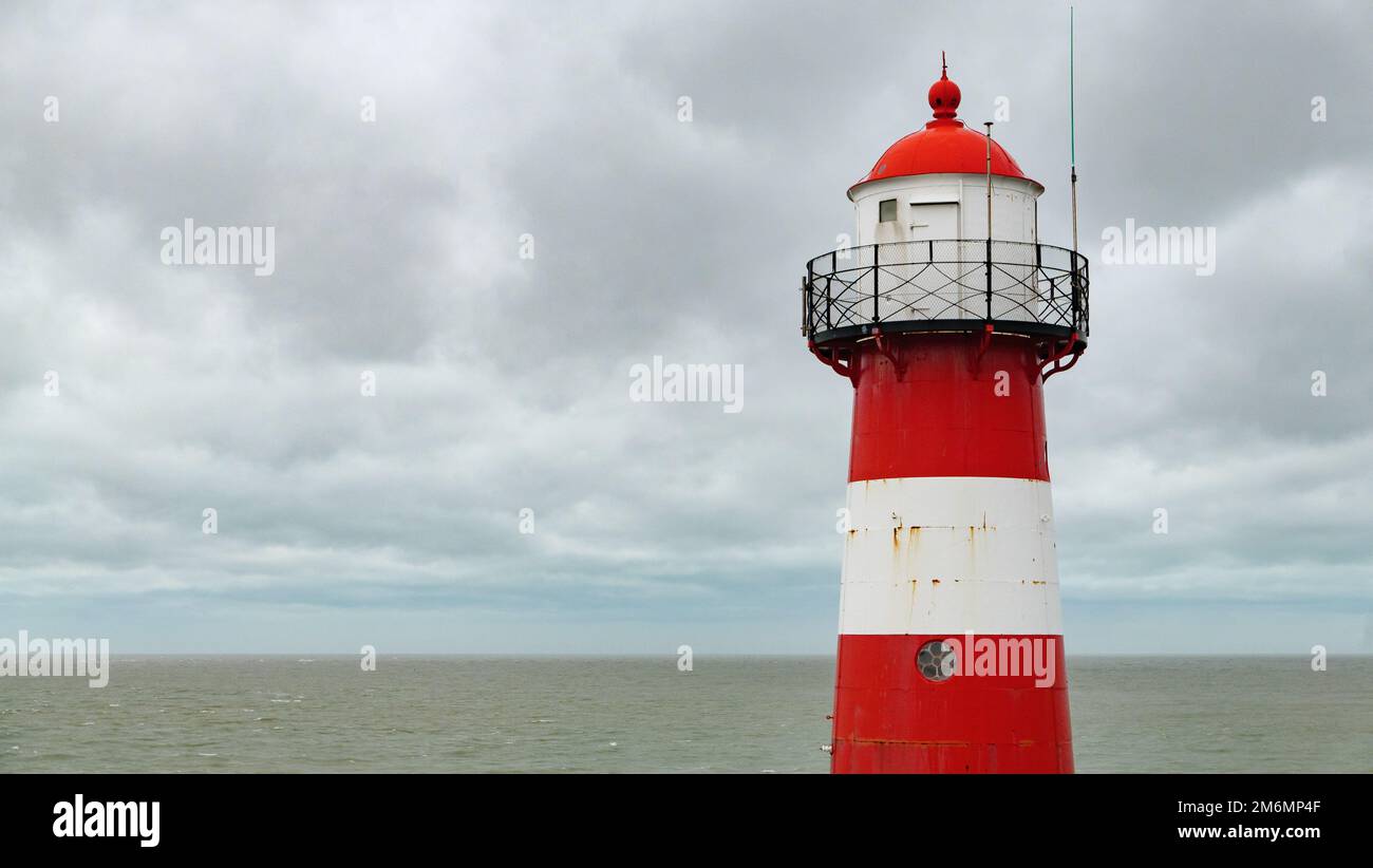 Faro rosso e bianco sul mare a westkapelle, walcheren, paesi bassi, in inverno Foto Stock