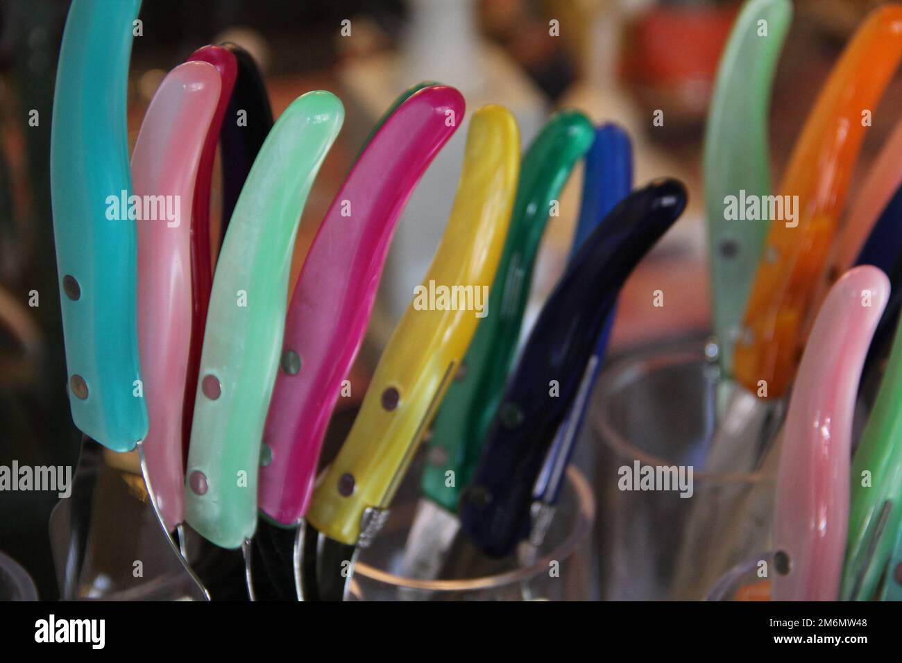 Il coltello colorato si impugna in ciotole trasparenti Foto Stock