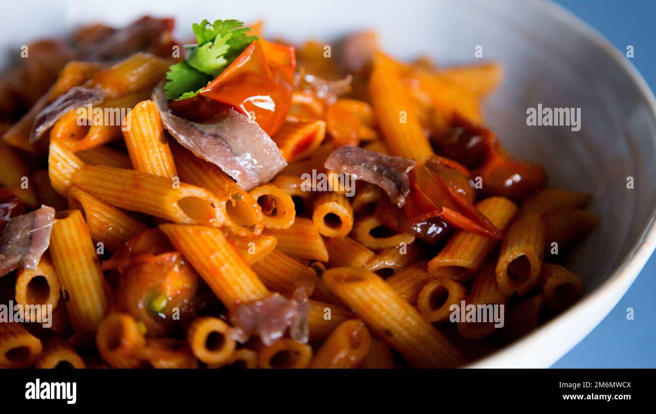 Pasta alla siciliana con acciughe. Pasta con salsa di pomodoro, basilico e olive nere. Foto Stock