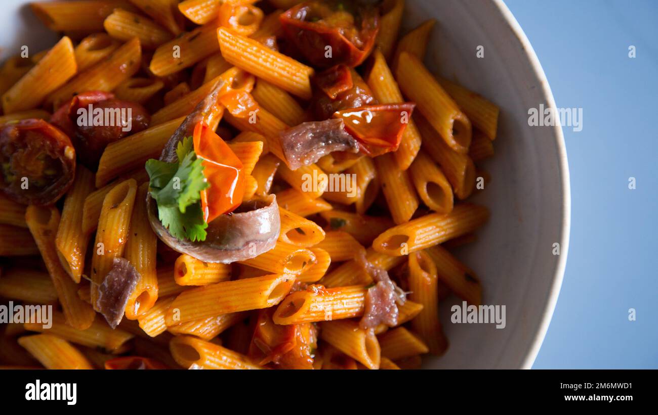 Pasta alla siciliana con acciughe. Pasta con salsa di pomodoro, basilico e olive nere. Foto Stock