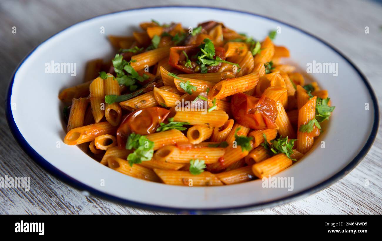 Pasta alla siciliana con acciughe. Pasta con salsa di pomodoro, basilico e olive nere. Foto Stock