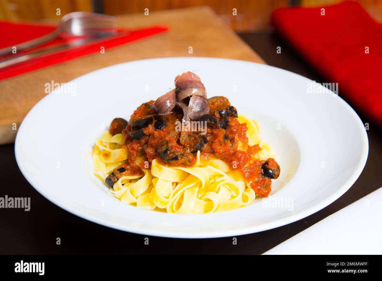 Pasta alla siciliana con acciughe. Pasta con salsa di pomodoro, basilico e olive nere. Foto Stock