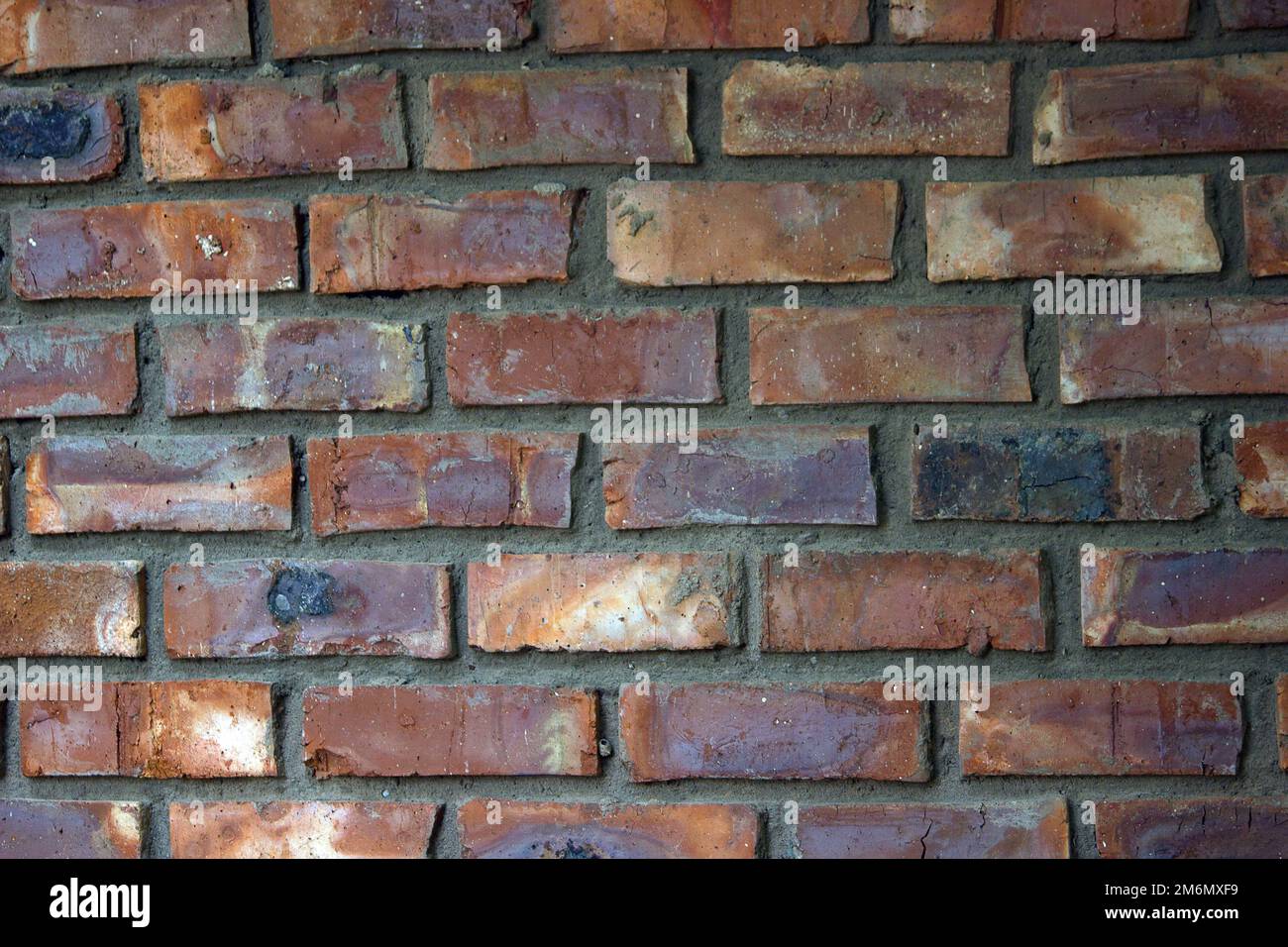 Mattoni colorati, colorati in parte di muro con mortaio che mostra in mezzo, può essere usato come sfondo Foto Stock