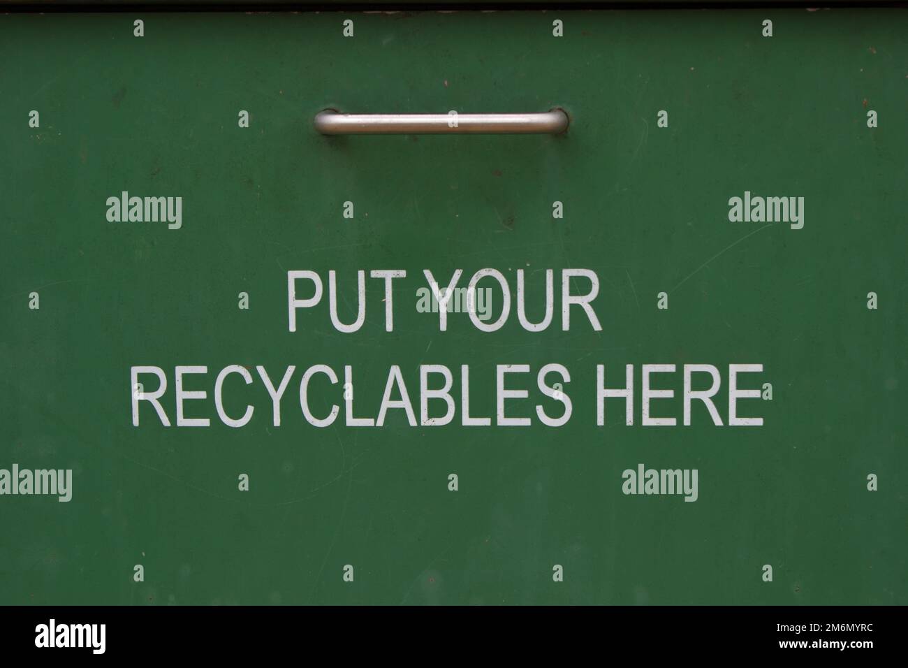 coperchio verde del contenitore metallico con le informazioni su come collocare i materiali riciclabili al suo interno Foto Stock