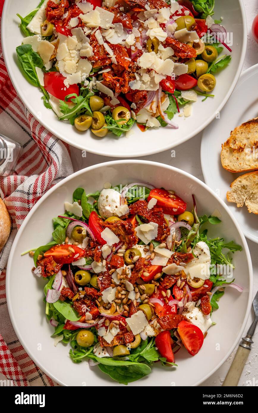 Pasto per due persone. Gustosa insalata di pomodori secchi con verdure fresche e mozzarella Foto Stock