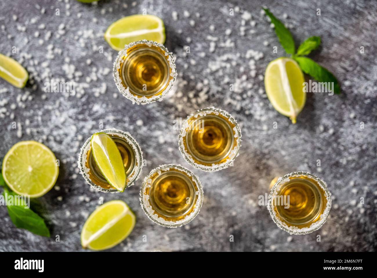 Vista dall'alto degli shot Golden Tequila serviti con calce e sale marino sul tavolo Foto Stock