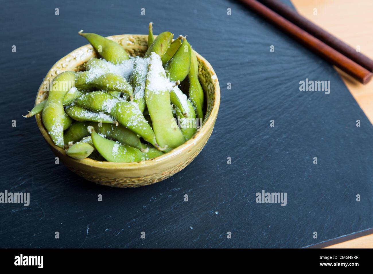 L'edamame è una preparazione di soia immatura nel baccello, che si trova in cucine con origini in Asia orientale. Le cialde vengono bollite o cotte al vapore e possono essere servite Foto Stock
