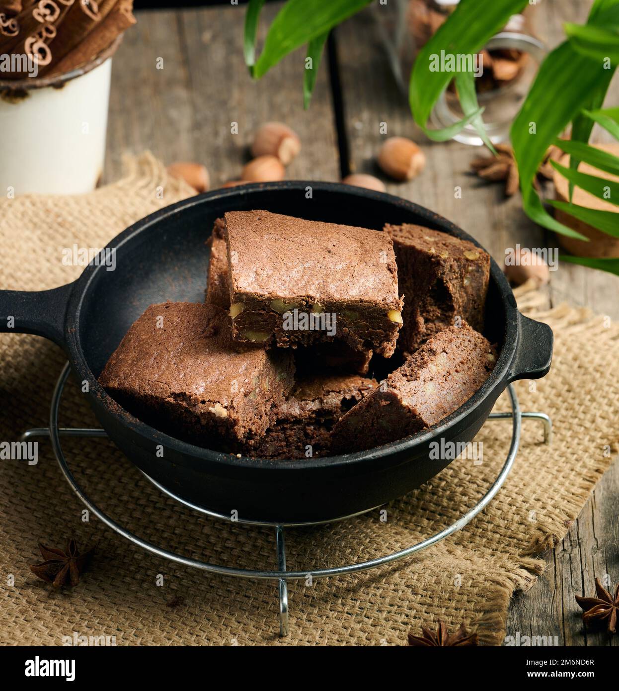 Pezzi di torta di brownie al cioccolato al forno con noci in una padella di metallo nero Foto Stock